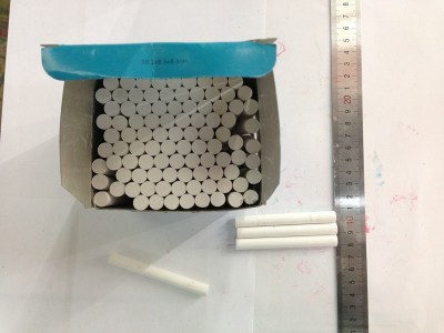 Box containing small sticks of white, monochrome chalk