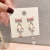 Korean version of fashion bow trend asymmetric student flower earrings wholesale origin source entity