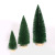 Christmas table tops are decorated with green pine needles and mini Christmas trees dusted with powder