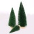 Christmas table tops are decorated with green pine needles and mini Christmas trees dusted with powder
