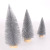 Christmas table tops are decorated with grey pine needles and mini Christmas trees dusted with powder