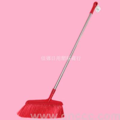 The red broom sweeps the plastic.