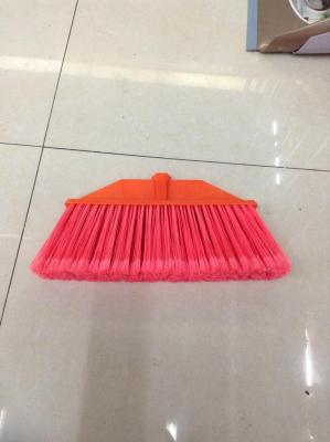 Sweep the head of a red plastic broom.