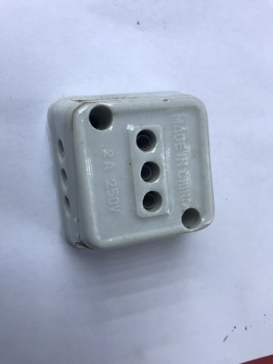 Ceramic plug socket with three holes.