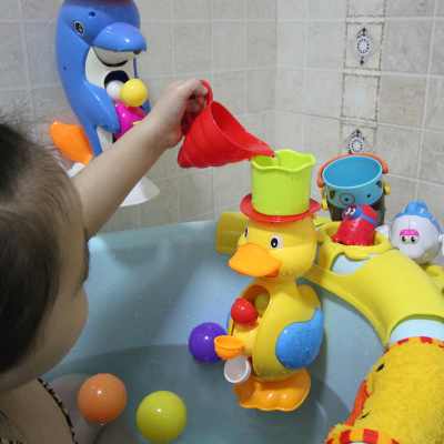 Baby bath toy boy and girl play on the beach in the bathroom and outdoors on a rhubarb duck