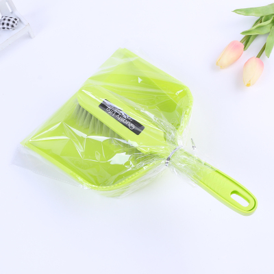 Household cleaning utensils a green shovel with a broom dustpan and brush