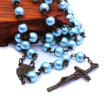 A necklace of blue pearls and rosary ornaments covered with stone crosses for who and Christian prayers