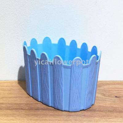 Plastic flowerpot with oval wooden fence basin